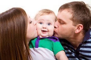 Mom and Dad Kissing Baby