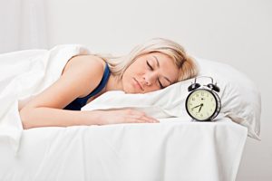 Woman Sleeping Next to Alarm Clock