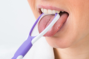 Woman Using a Tongue Scraper