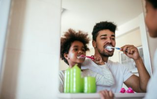 Man Brushing Childs Teeth