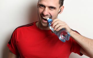 Man Opening Water Bottle with Teeth